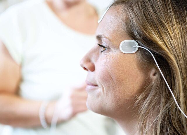 Eine Frau im Profil, welche Elektroden an der Schläfe hat.