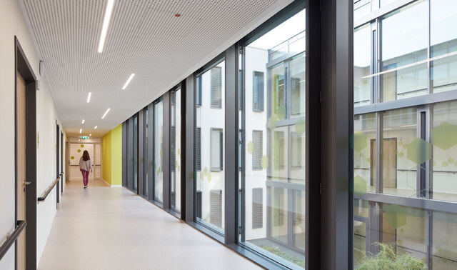 Flur in der Klinik Könighof, dieser hat auf seiner rechten Seite eine komplette Fensterfassade.